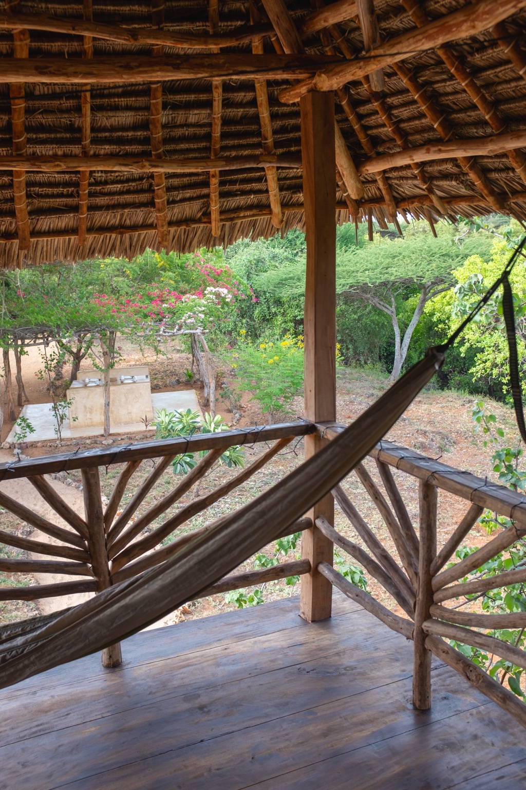 Hammock strung across the treehouse deck, looking out over bougainvillea in the garden
