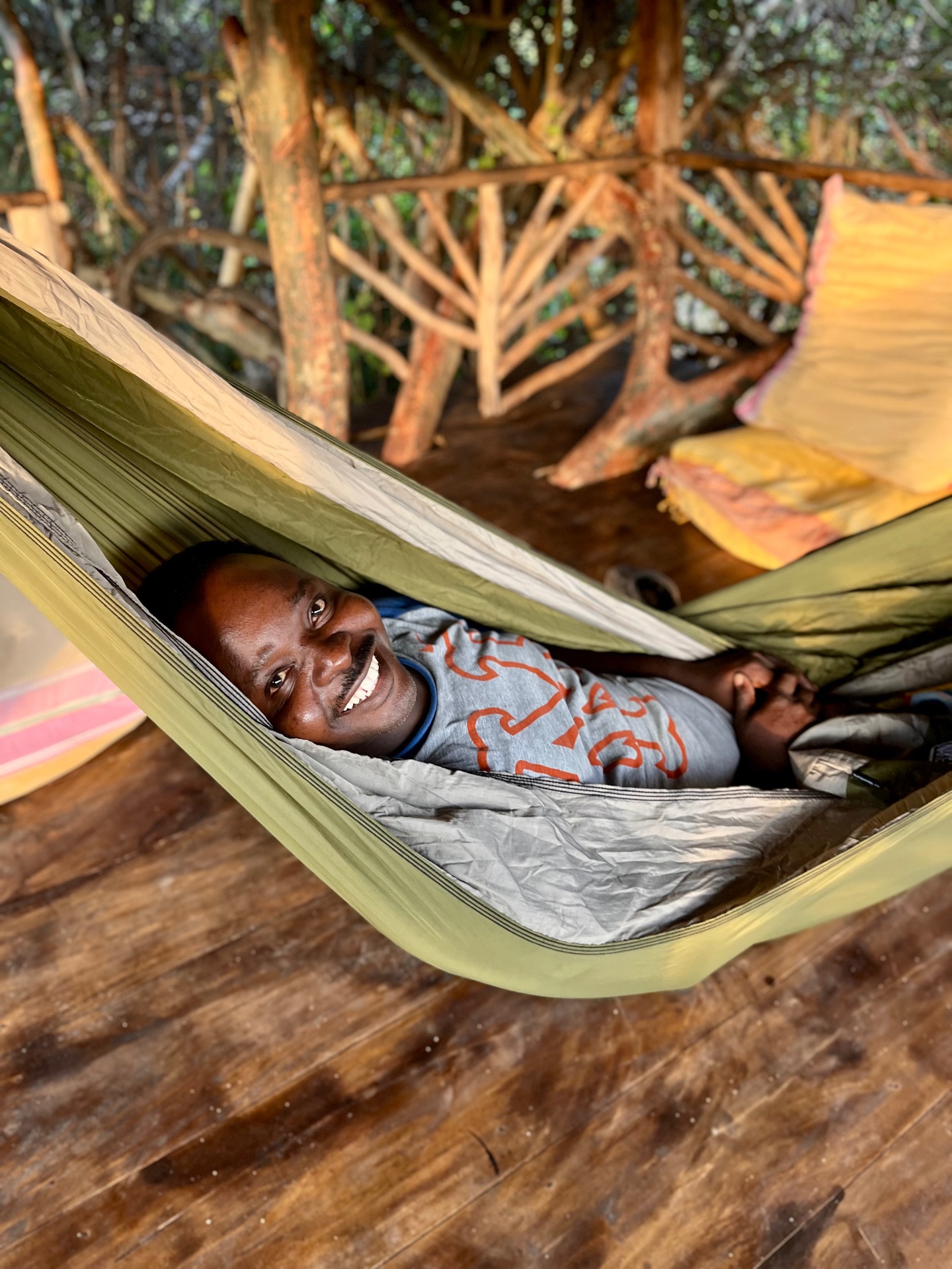 Idi resting in a hammock on the timber deck of the treehouse at Mkoko